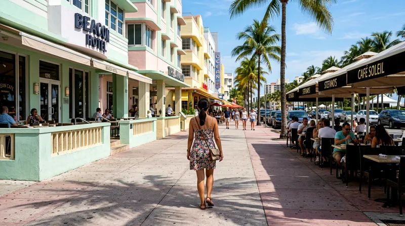 Solo visitor walking down Ocean Drive past pastel storefronts and sidewalk cafés in midday light.