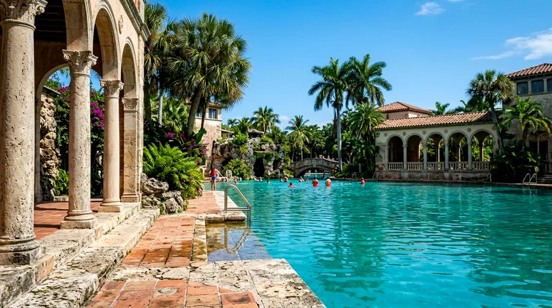 The Venetian Pool's Mediterranean-style colonnades frame turquoise water with swimmers and palm trees