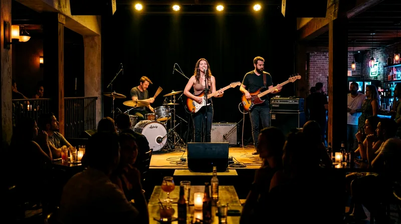 Live band performing on stage under warm spotlight with audience watching from tables.